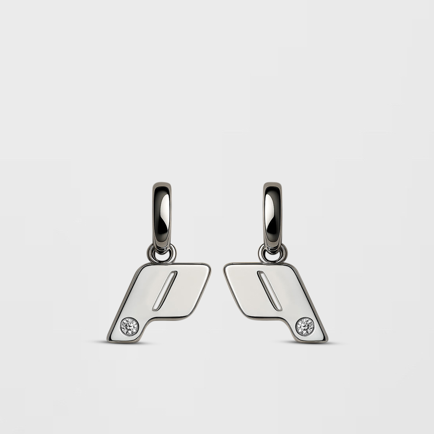 A pair of sterling silver drop earrings with a natural diamond detail, photgraphed on a Cloudstone Grey background. Part of the OTR: On The Run collection.
