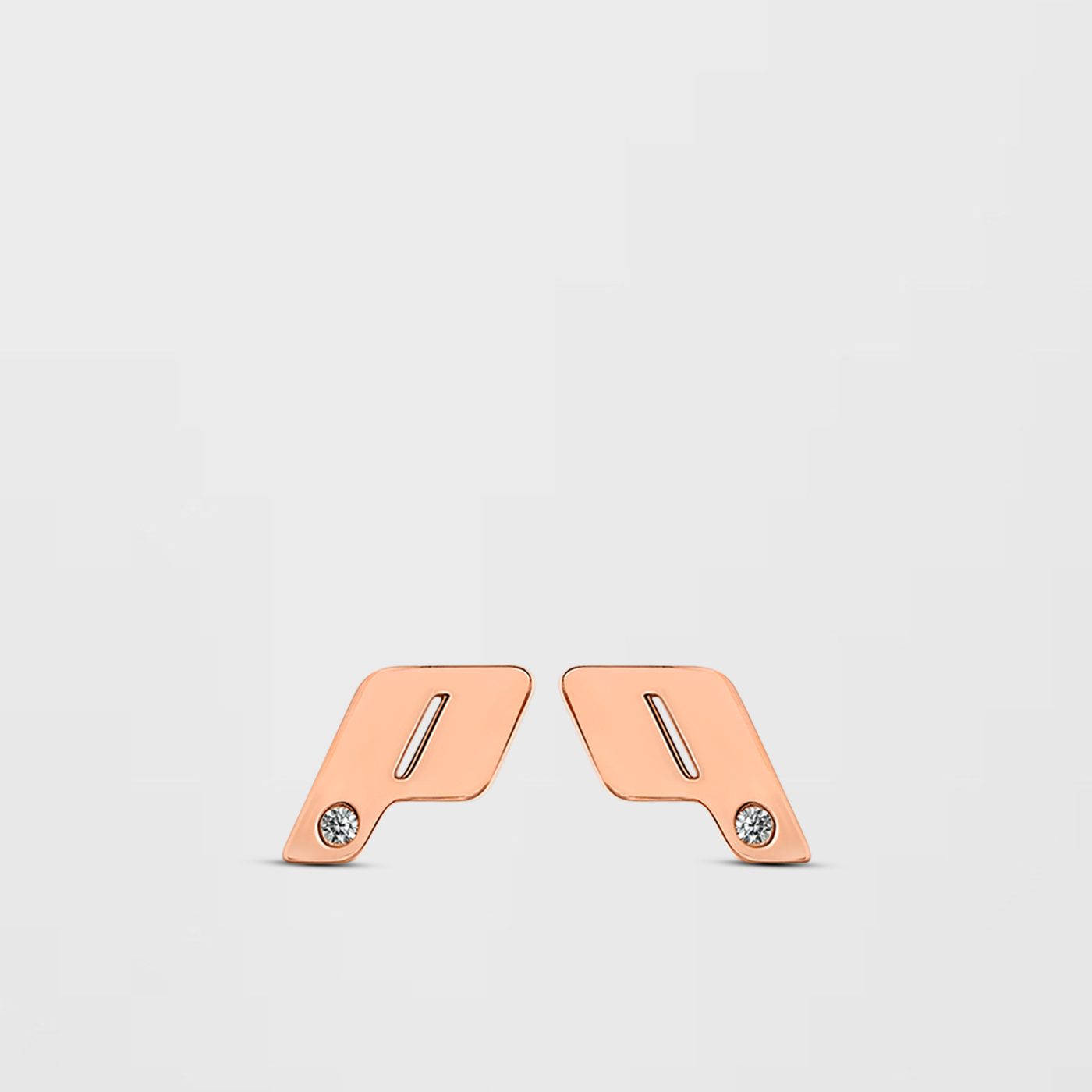 Apair of 18k rose gold Play monogram stud earrings., each set with a natural VVS diamond accent, photographed on a Cloudstone Grey backdrop
